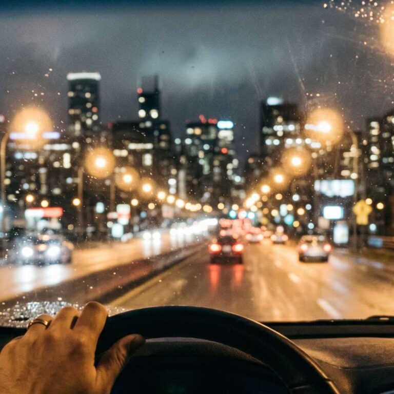 Driver looking out over the steering wheel with blurred vision and haloed lighting.